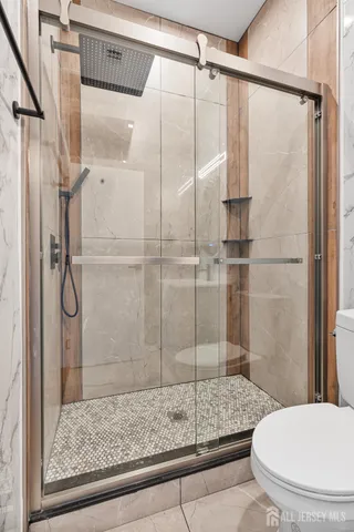 a bathroom with a granite countertop shower a toilet and sink