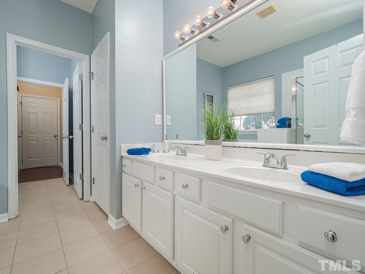 8429 Whisper Ridge Place Raleigh, NC 27613 - Photo 13 of 27 The master bath offers dual vanities, tiled flooring , private WC and access to the laundry room