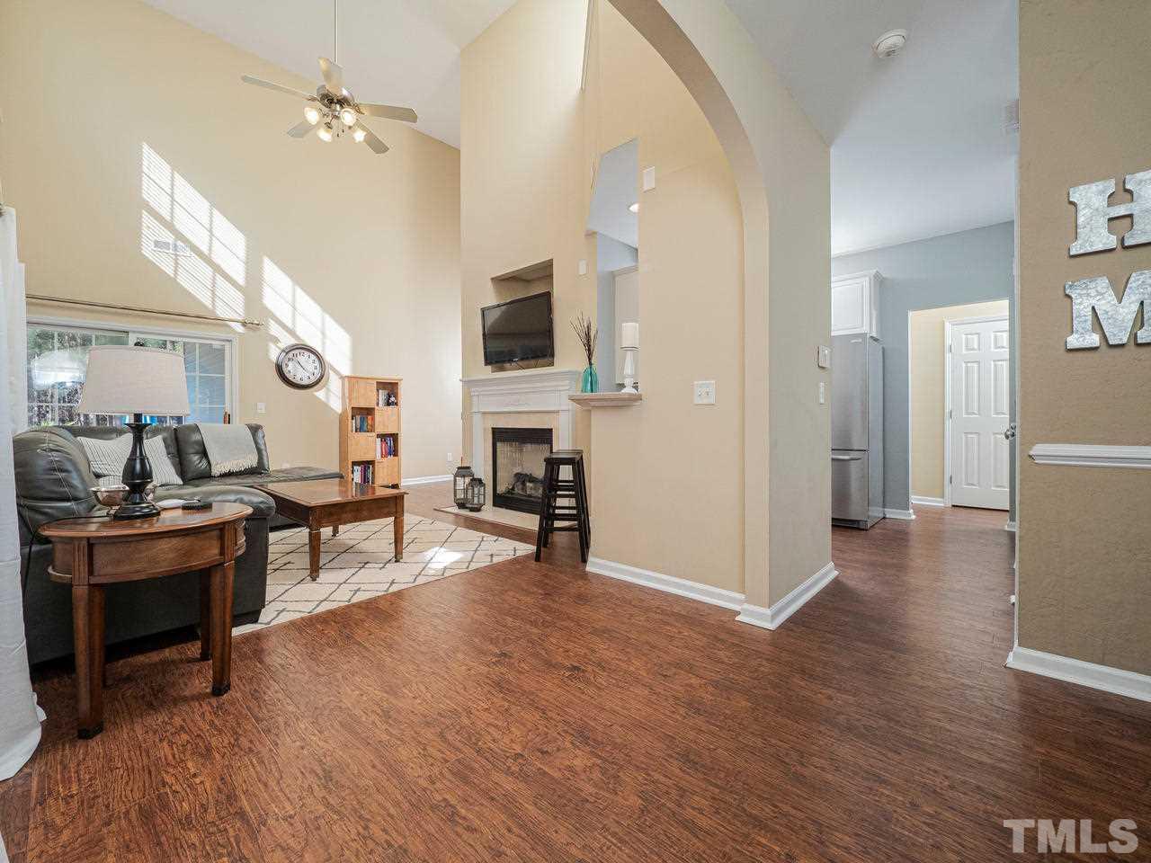 8429 Whisper Ridge Place Raleigh, NC 27613 - Photo 5 of 27 Tall ceilings in the Family with high bar area into kitchen, Gas fireplace and Sliding glass doors to covered patio area and backyard
