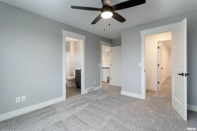 an empty room with closet and a ceiling fan