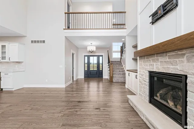 a view of a livingroom with wooden floor and a fireplace