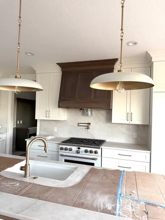 a kitchen with stainless steel appliances granite countertop a sink a stove and a wooden floor