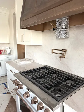 a stove sitting inside of a kitchen with white cabinets