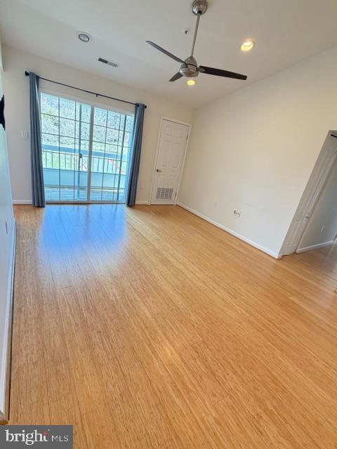 8399 Montgomery Run Road, Unit I Ellicott City, MD 21043 - Photo 12 of 26 an empty room with wooden floor and windows