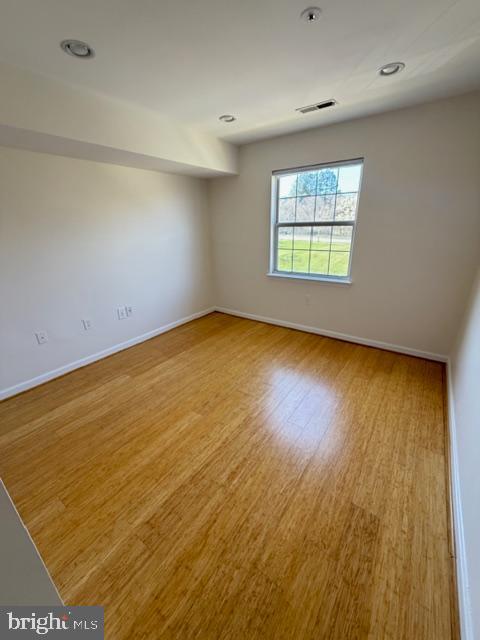 8399 Montgomery Run Road, Unit I Ellicott City, MD 21043 - Photo 15 of 26 an empty room with wooden floor and windows