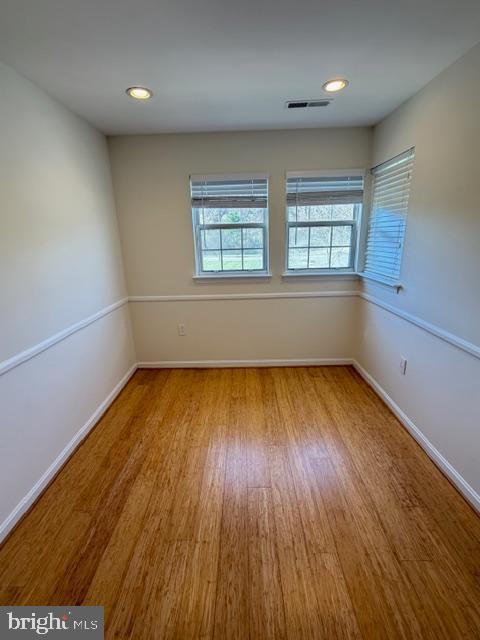 8399 Montgomery Run Road, Unit I Ellicott City, MD 21043 - Photo 10 of 26 an empty room with wooden floor and windows