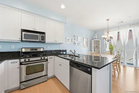 a kitchen with granite countertop a sink appliances and cabinets