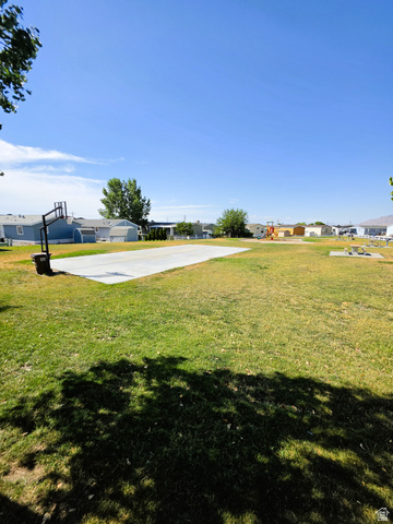 1604 180 East Tooele, UT 84074 - Photo 14 of 16 Expansive green space featuring a concrete sports court and a basketball hoop