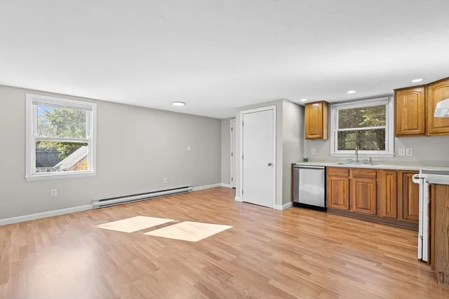 a view of a kitchen with wooden floor and a window