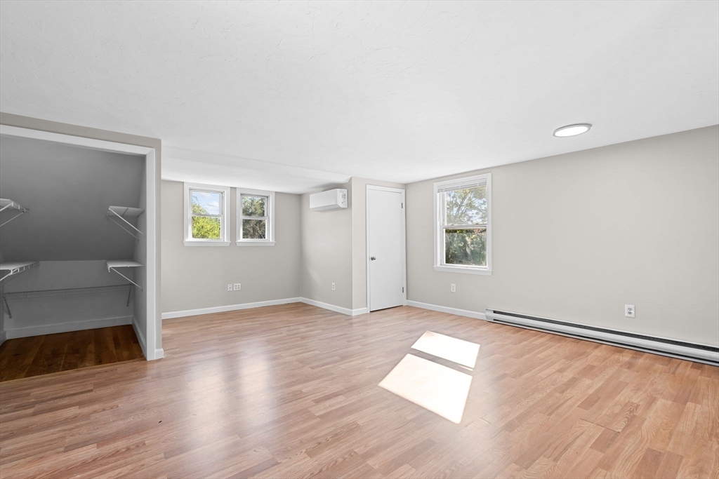 9 Home Avenue, Unit 2 Natick, MA 01760 - Photo 11 of 19 an empty room with wooden floor and windows