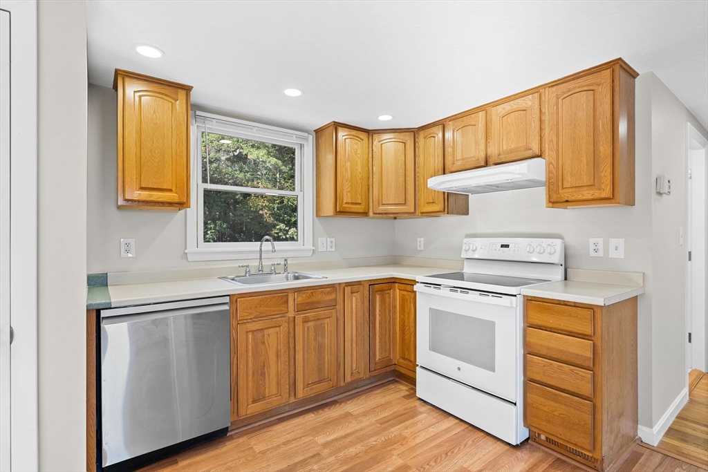 9 Home Avenue, Unit 2 Natick, MA 01760 - Photo 6 of 19 a kitchen with a sink cabinets wooden floor and stainless steel appliances