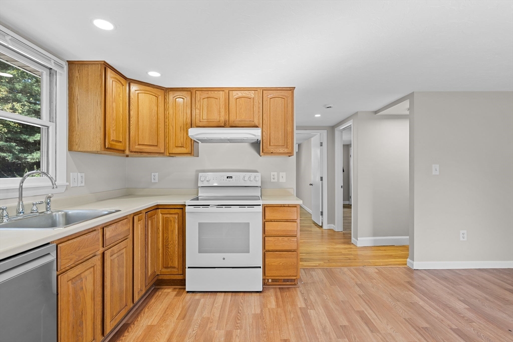 9 Home Avenue, Unit 2 Natick, MA 01760 - Photo 7 of 19 a kitchen with wooden floors and white stainless steel appliances