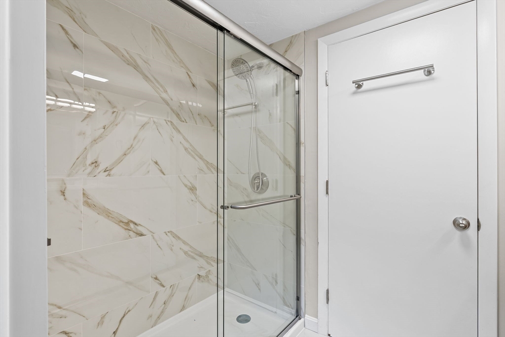 9 Home Avenue, Unit 2 Natick, MA 01760 - Photo 10 of 19 a bathroom with a glass shower door and a bathtub