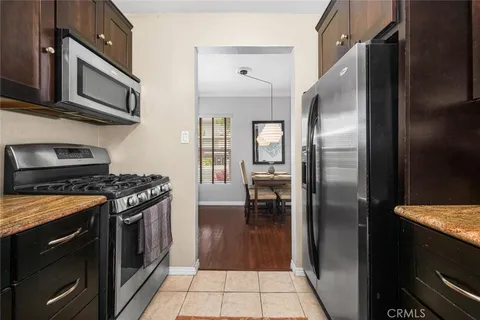 a kitchen with stainless steel appliances granite countertop a stove a refrigerator and a microwave