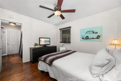 a bedroom with a bed and wooden floor