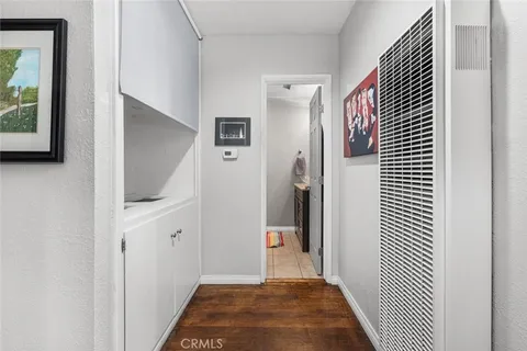 a view of a hallway with bathroom and wooden floor