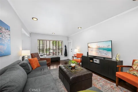 a living room with furniture a large window and a flat screen tv