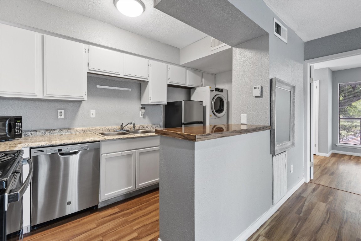13151 Walden Road, Unit 172 Montgomery, TX 77356 - Photo 7 of 19 a kitchen with stainless steel appliances granite countertop a refrigerator and a stove top oven