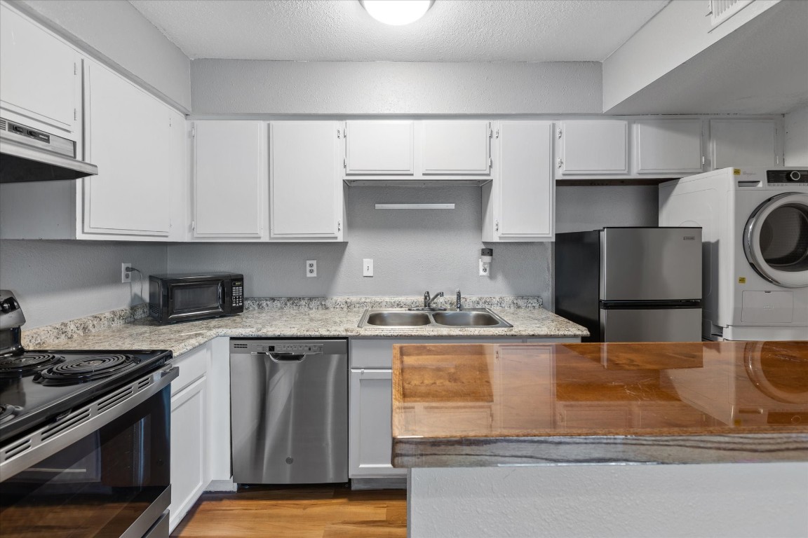 13151 Walden Road, Unit 172 Montgomery, TX 77356 - Photo 8 of 19 a kitchen with granite countertop a sink a stove and cabinets