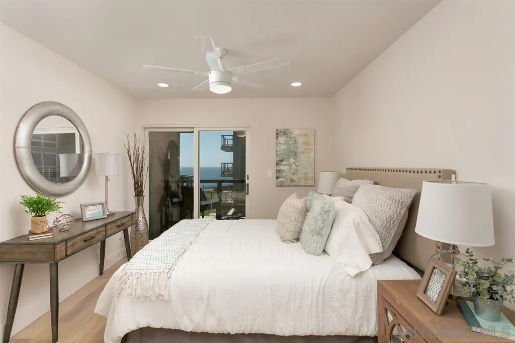 940 Sealane Drive, Unit 6 Encinitas, CA 92024 - Photo 13 of 24 a bedroom with a bed a mirror table and chair