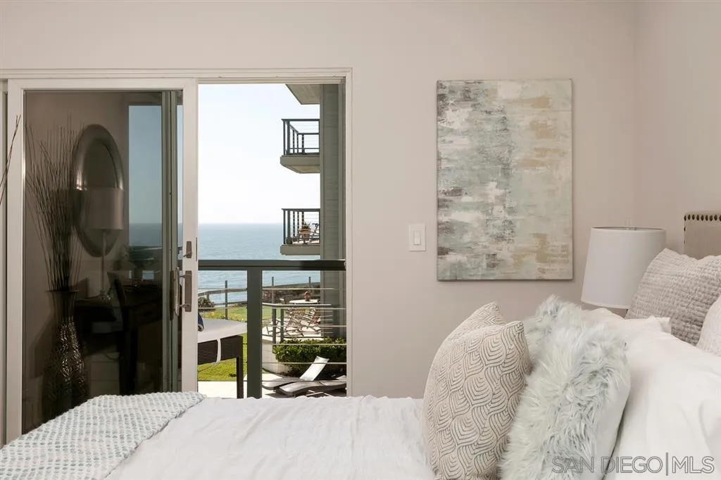 940 Sealane Drive, Unit 6 Encinitas, CA 92024 - Photo 14 of 24 a bedroom with a bed and a mirror