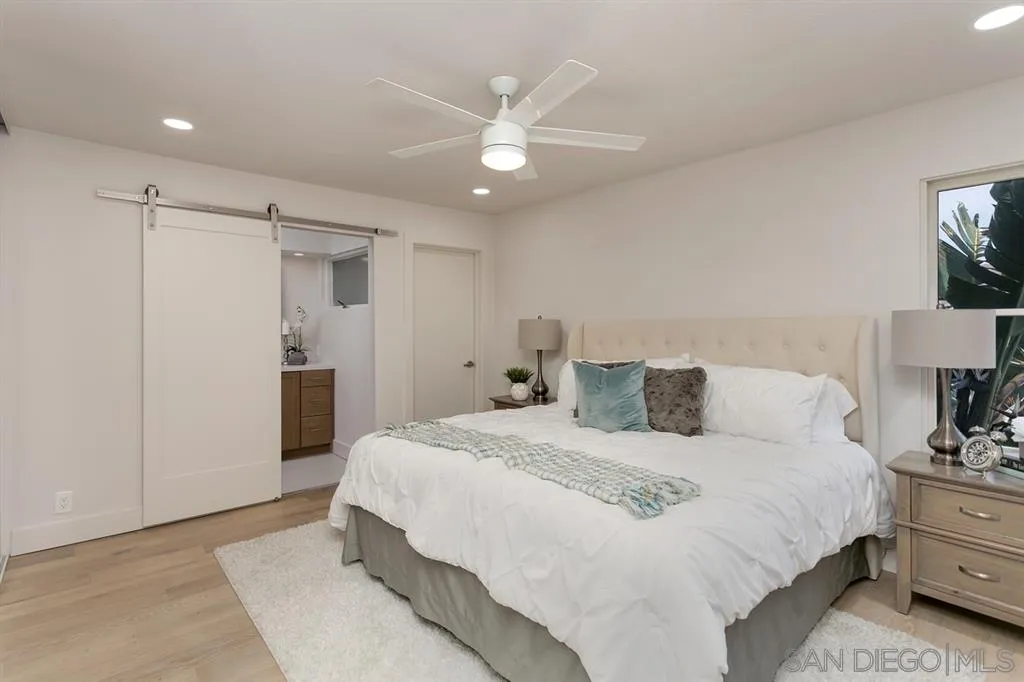 940 Sealane Drive, Unit 6 Encinitas, CA 92024 - Photo 21 of 24 a spacious bedroom with a bed and a lamp