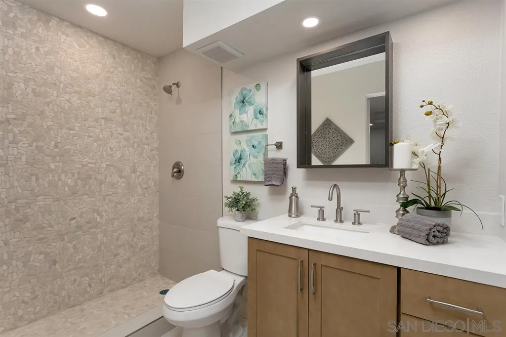 940 Sealane Drive, Unit 6 Encinitas, CA 92024 - Photo 22 of 24 a bathroom with a sink a toilet and a mirror