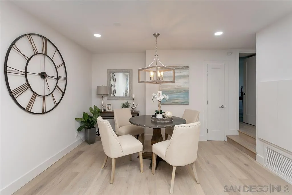 940 Sealane Drive, Unit 6 Encinitas, CA 92024 - Photo 6 of 24 a dining room with wooden floor a chandelier a glass table and chairs