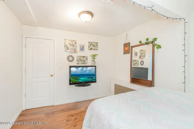 a bedroom with a bed and a painting on the wall