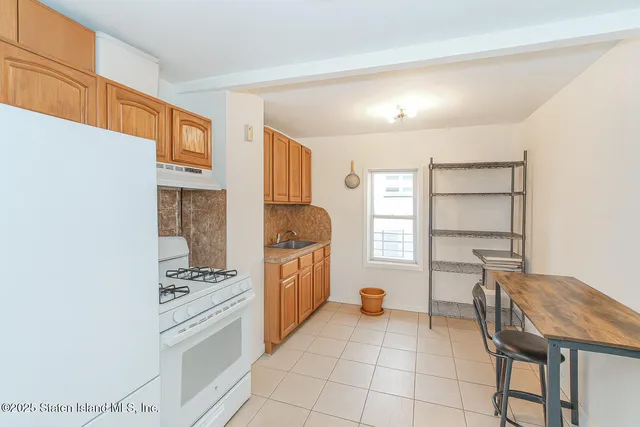a kitchen with stainless steel appliances kitchen island granite countertop a refrigerator and cabinets