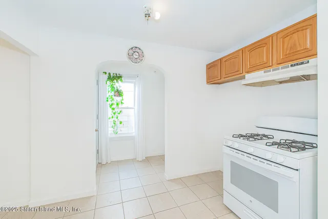 a kitchen with a stove a sink and a window