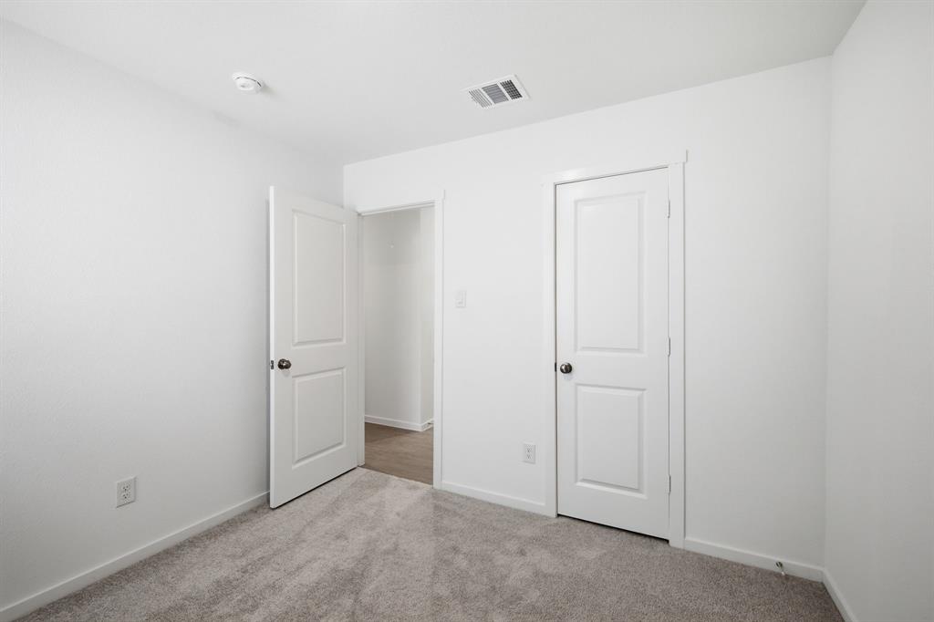 2128 Doc Holliday Road Joshua, TX 76058 - Photo 9 of 28 Neutral-toned carpeting complements the white walls and trim in this room featuring a two-panel interior door and a smoke detector
