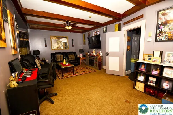 a living room with furniture a flat screen tv and a fireplace