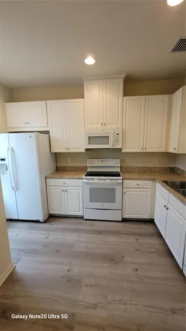 a kitchen with white cabinets and white appliances