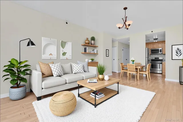 a living room with furniture potted plant and kitchen view