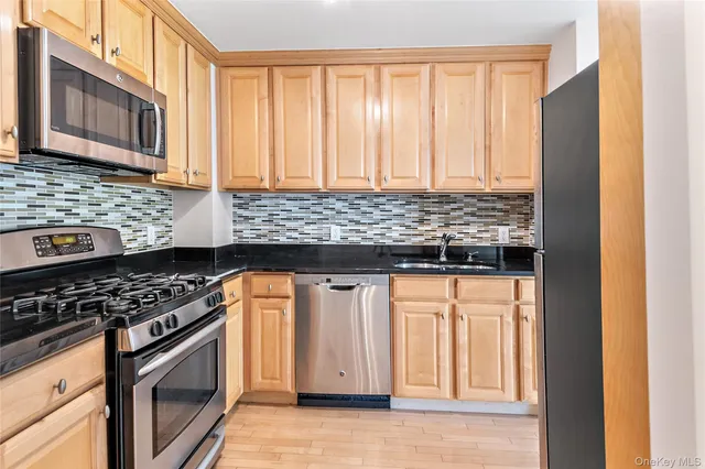 a kitchen with stainless steel appliances granite countertop a stove and a microwave