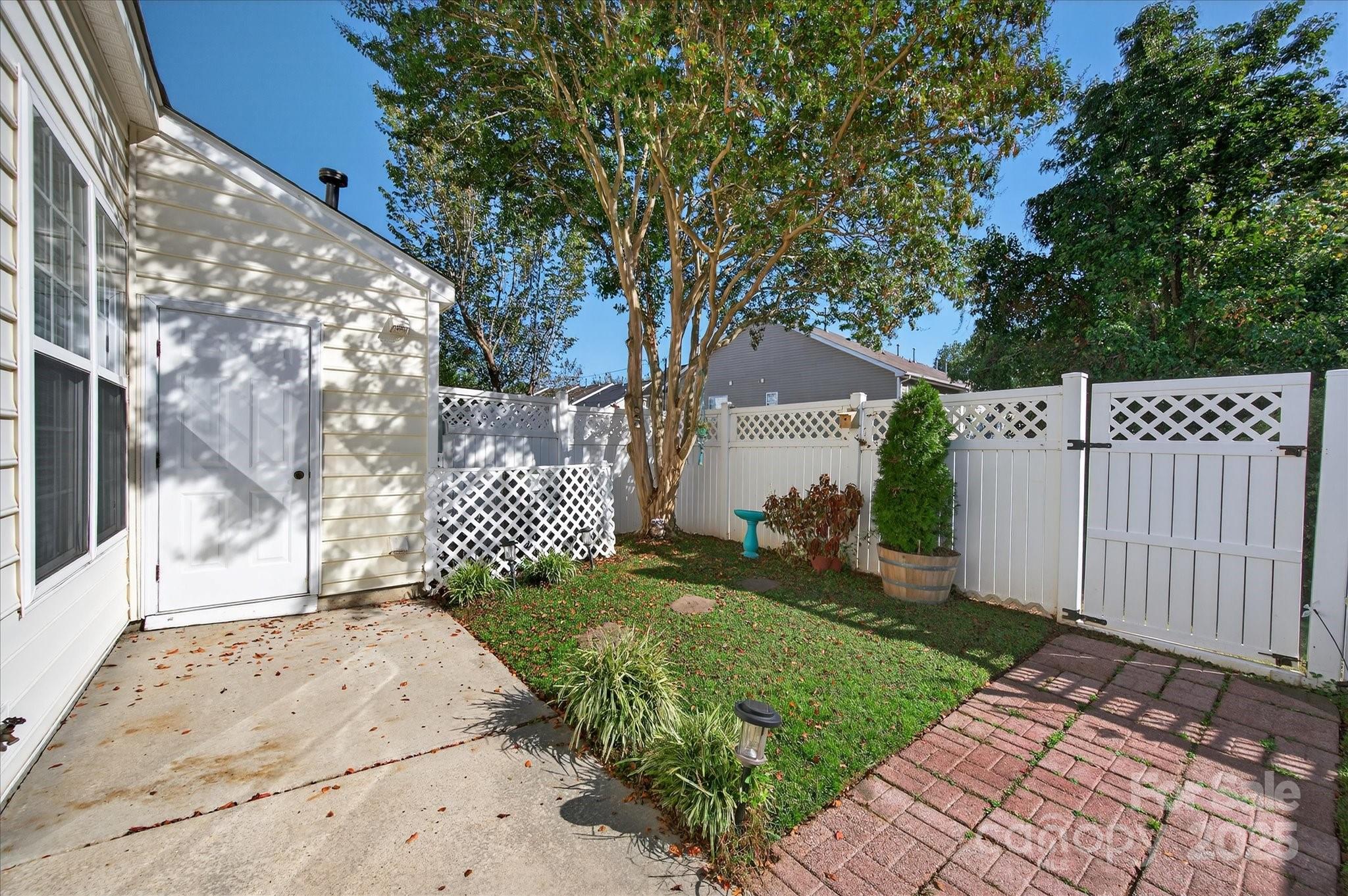 1119 Sienna Sand Way Fort Mill, SC 29708 - Photo 32 of 36 a view of a yard with brick wall and a large tree