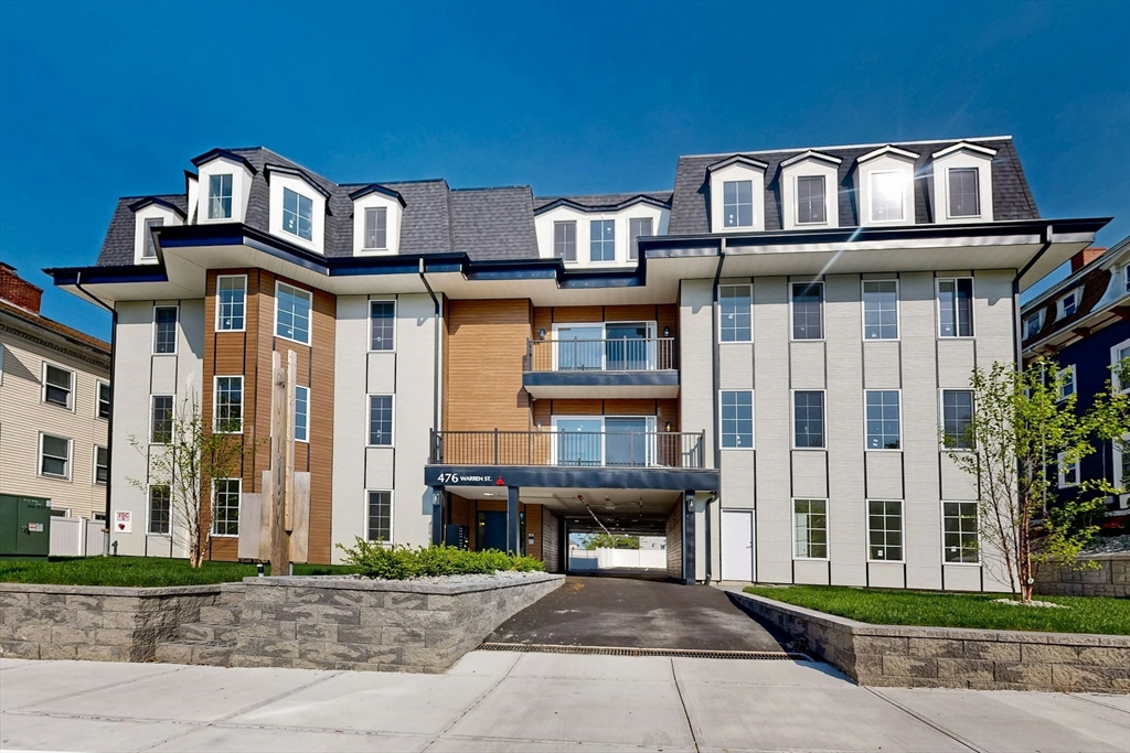 a front view of a residential apartment building with a yard