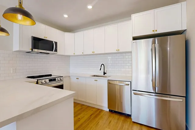 a kitchen with stainless steel appliances a refrigerator sink and microwave