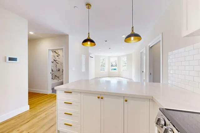 a view of kitchen with cabinets and window