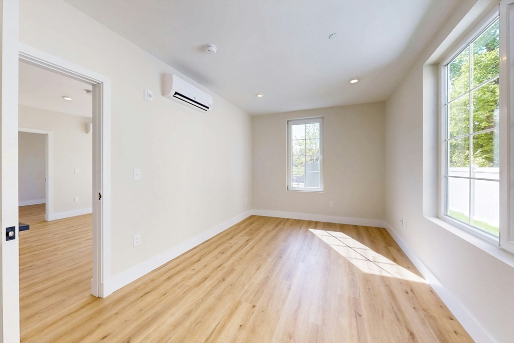 476 Warren Street Boston, MA 02121 - Photo 16 of 29 an empty room with wooden floor and windows
