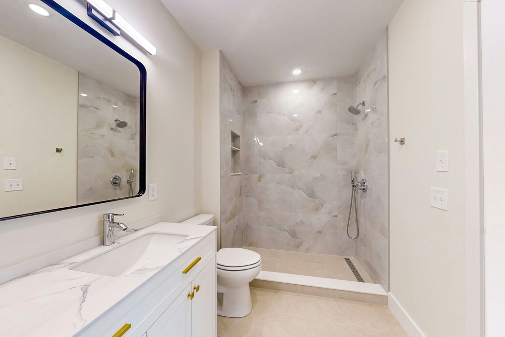 476 Warren Street Boston, MA 02121 - Photo 20 of 29 a bathroom with a granite countertop sink a toilet and shower