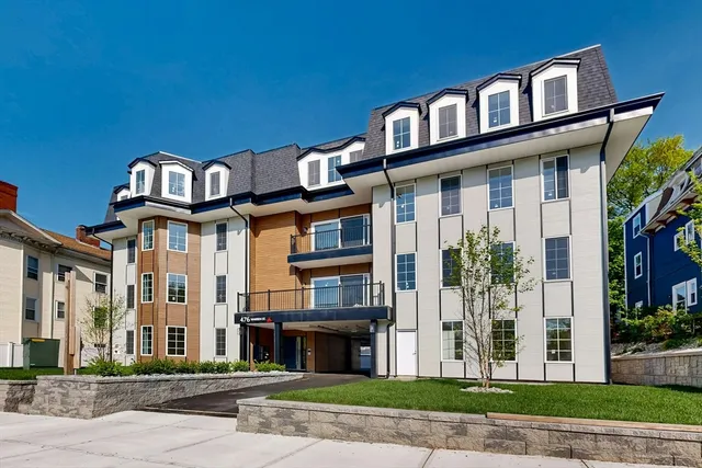 a front view of a residential apartment building with a yard