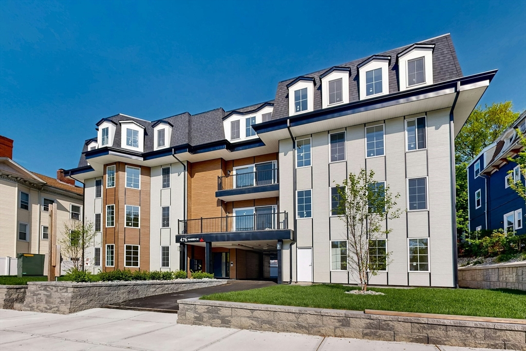 476 Warren Street Boston, MA 02121 - Photo 2 of 29 a front view of a residential apartment building with a yard
