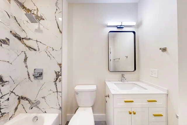 a bathroom with a sink mirror vanity and toilet