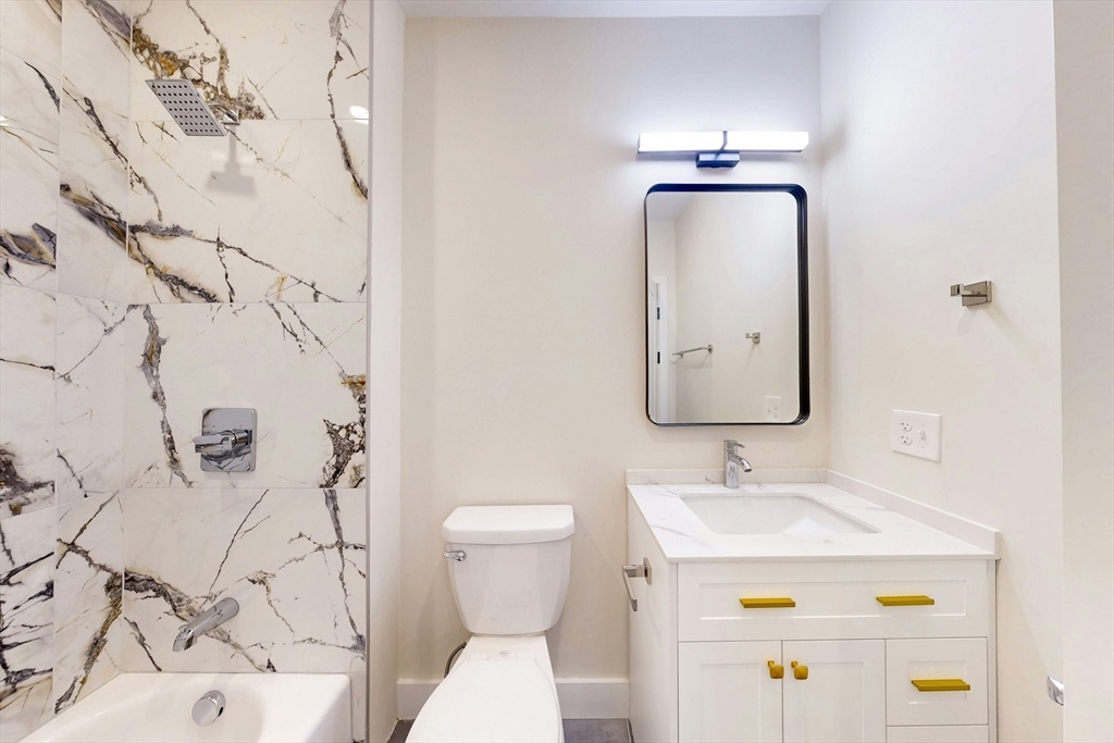 476 Warren Street Boston, MA 02121 - Photo 24 of 29 a bathroom with a sink mirror vanity and toilet