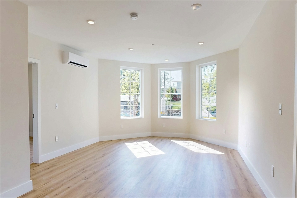 476 Warren Street Boston, MA 02121 - Photo 7 of 29 a view of empty room with wooden floor and fan