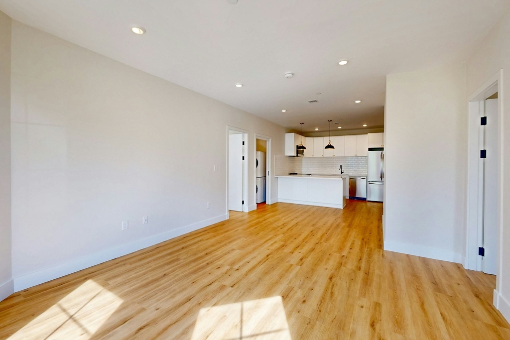 476 Warren Street Boston, MA 02121 - Photo 9 of 29 a big room with wooden floor and natural light