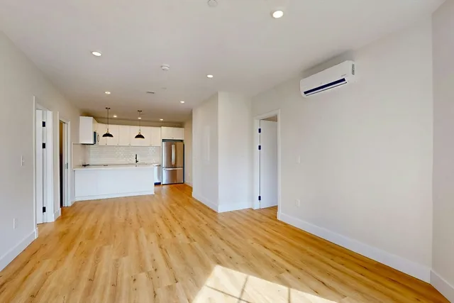 a big room with wooden floor and a bathroom