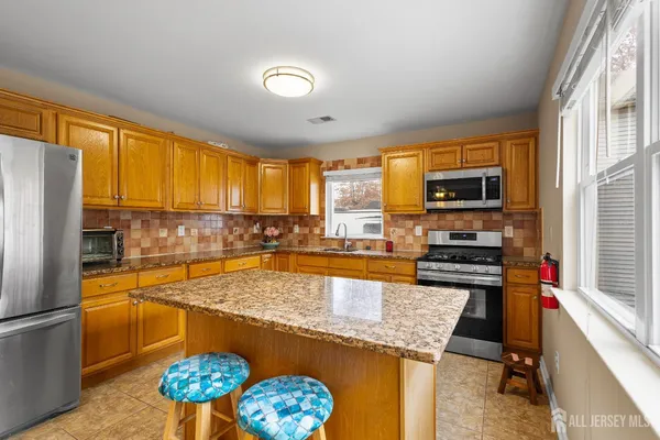 a kitchen with stainless steel appliances a stove refrigerator sink and microwave